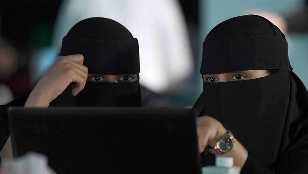 نساء منقبات يستخدمن الحاسوب