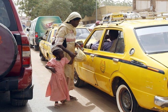امرأة سودانية نازحة من (دارفور) تتسول وتتوسل المارة من أجل القليل من المال