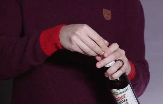 يد تفتح زجاجة بواسطة شريط لاصق