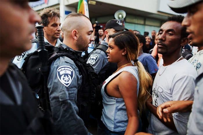 إمرأة إسرائيلية تقف ضد وحشية الشرطة خلال احتجاج في (تل أبيب).