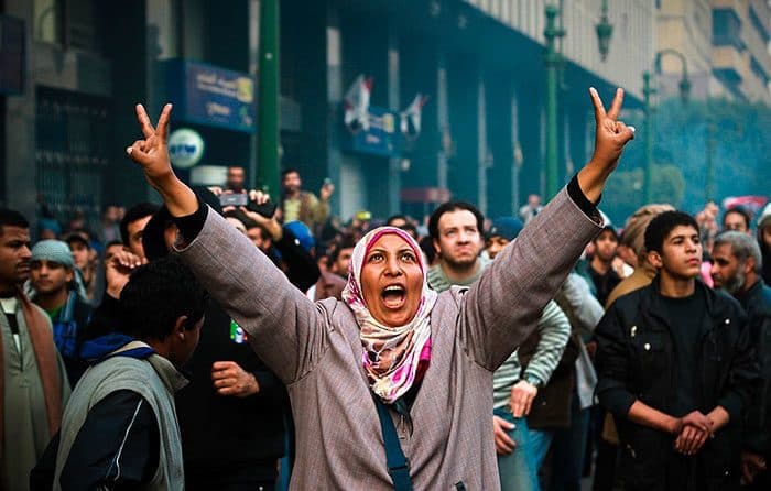 محتجَّة تلوح بإشارة النصر خلال التحامات مع الشرطة العسكرية بالقرب من ميدان التحرير في مصر، 17 كانون الثاني/يناير 2013.