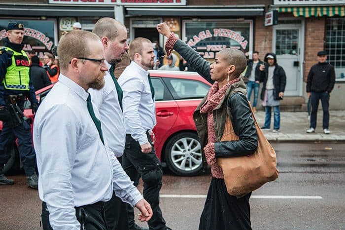 (ماريا-تيريزا أسبلوند) Maria-Teresa Asplund الملقبة بـ”تِس“ تقف في وجه متظاهرين يرتدون زيًّا موحَّداً في إحدى تظاهرات النازيين في (بورلينغه – السويد)، في 1 حزيران/مايو 2015.