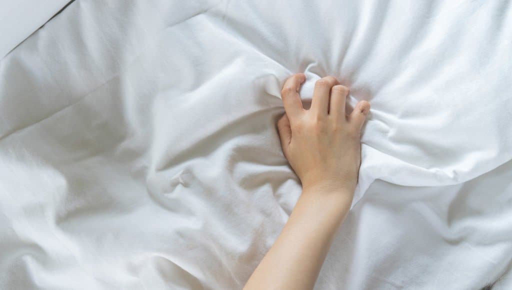 ذراع امرأة على فراش أبيض