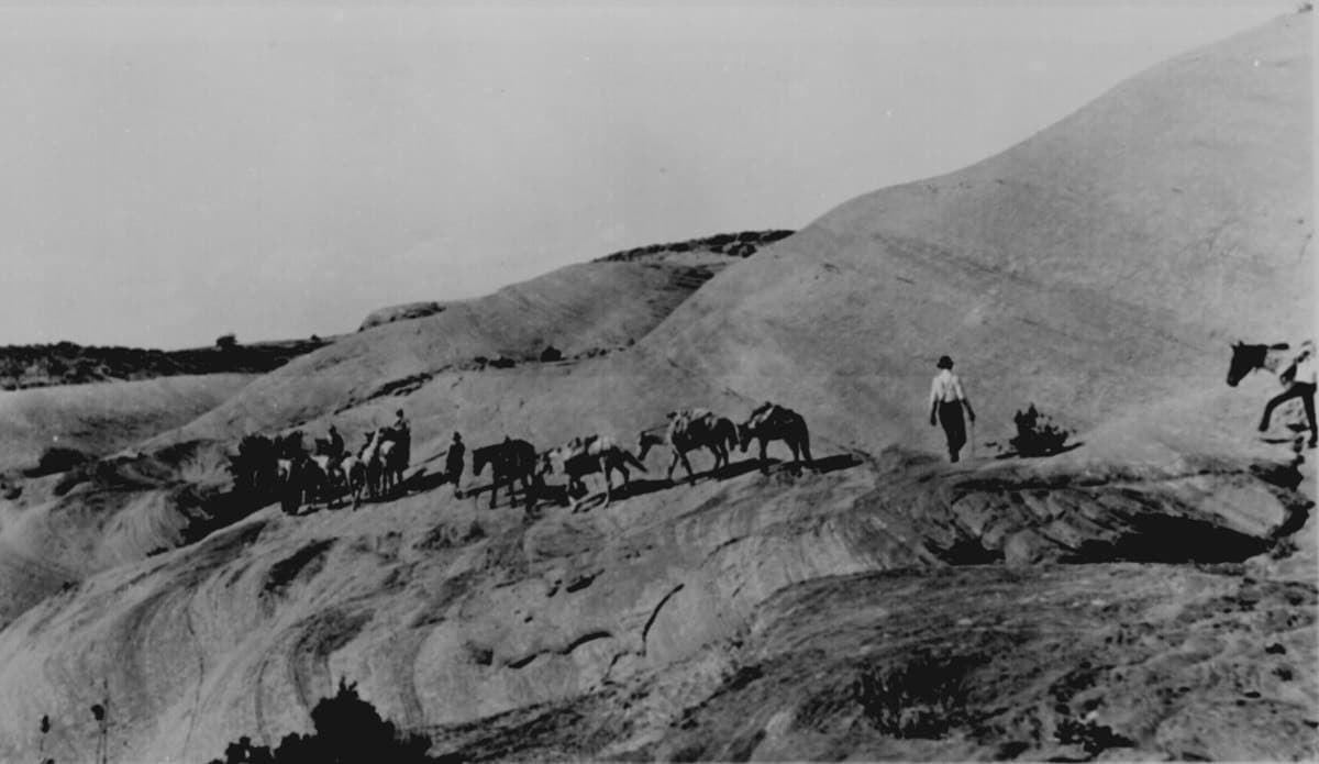 مجموعة من المستوطنين يقودون خيولهم عبر الصخور الملساء والحارة لجبل (نافاخو) في (يوتاه) سنة 1909.