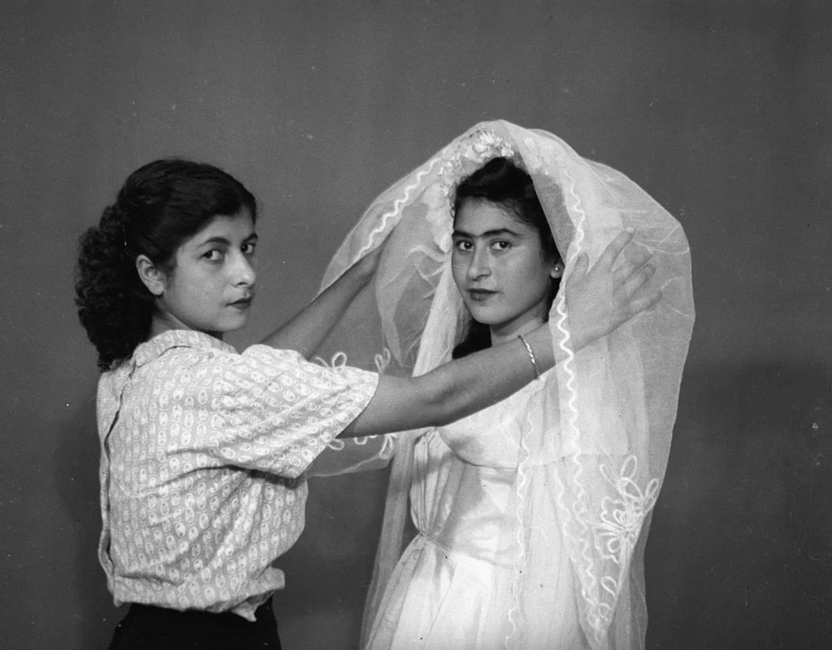 شابة بزي العروس التقليدي تكشف عنها النقاب أختها.
