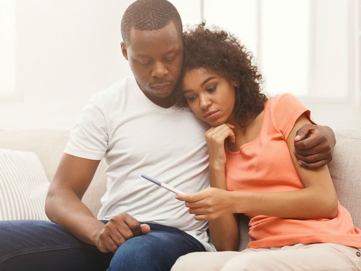 امرأة وشريكها يحملان اختبار الحمل