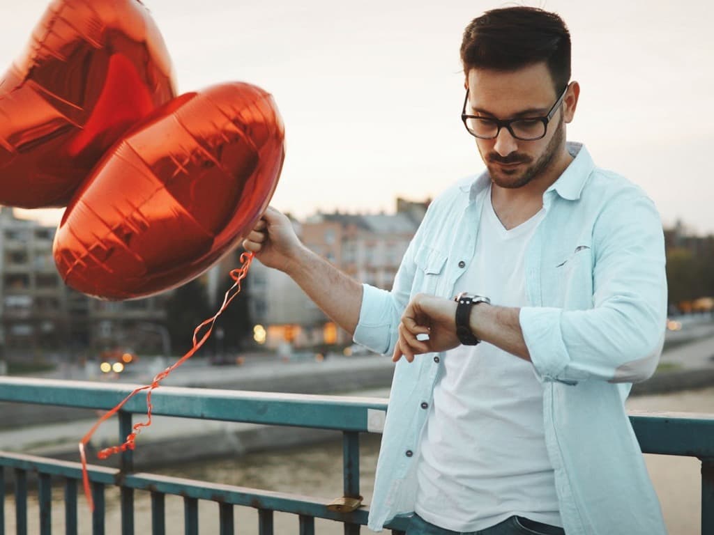 شاب يحمل بالونات على شكل قلب