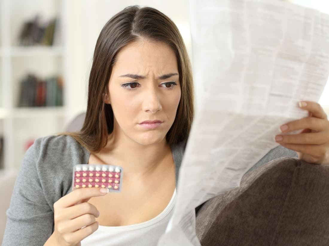 امرأة تحمل نشرة حبوب منع الحمل