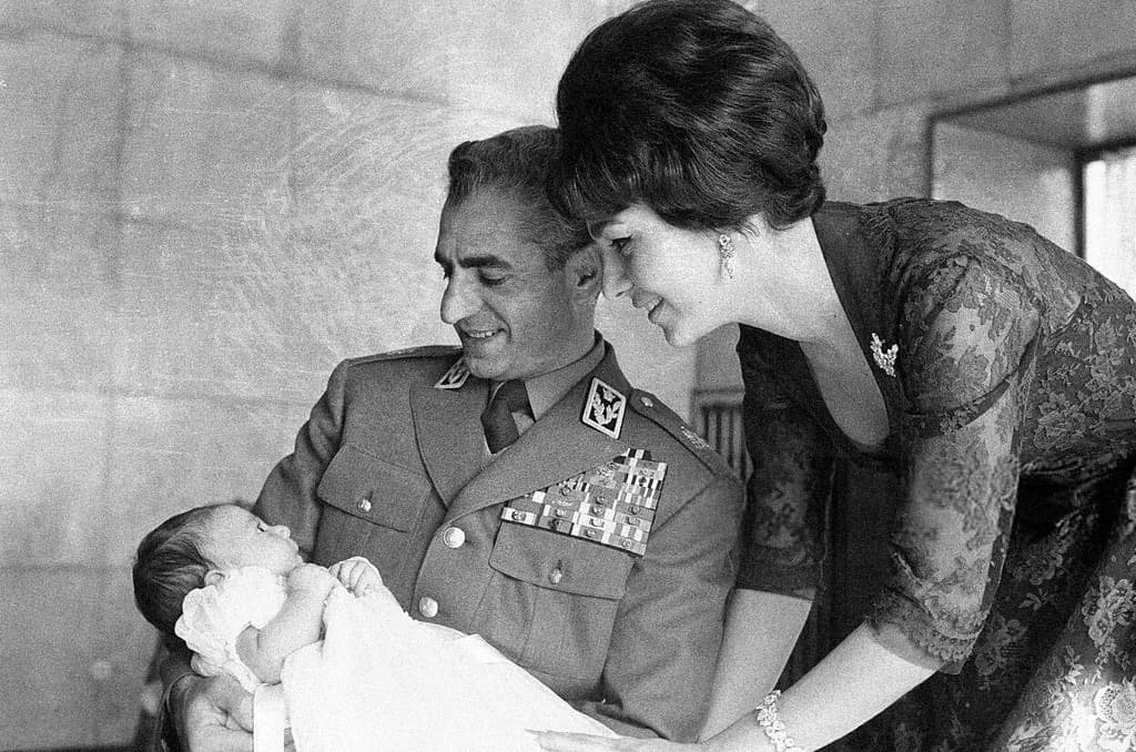 صورة تجمع الشاه وهو يرتدي الزي العسكري ويجلس على ركبتيه أمام ابنه المولود حديثا (رضا بهلوي الثاني) وزوجته (فرح ديبا) في ديسمبر 1960. صورة: Jack Garofalo/Paris Match/Getty Images