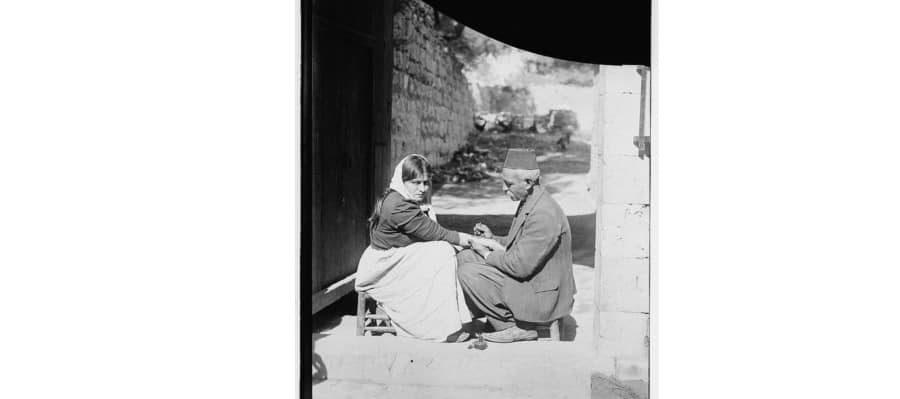 46. صورة لرسام الوشوم وصائغ الذهب (نرسيس) أثناء قيامه برسم وشم لامرأة أرمنية مهاجرة في مشغله الواقع تحت البطريركية الأرمنية في الحي الأرمني بالقدس بين عامي 1911-1900.