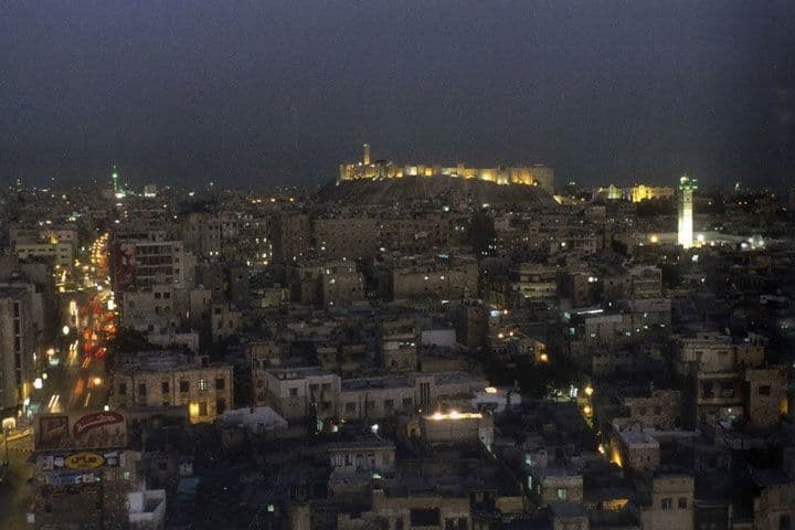 صورة لمدينة حلب عند المساء؛ تظهر في الصورة قلعتها الشهيرة ومنارة مسجدها الأمويّ.