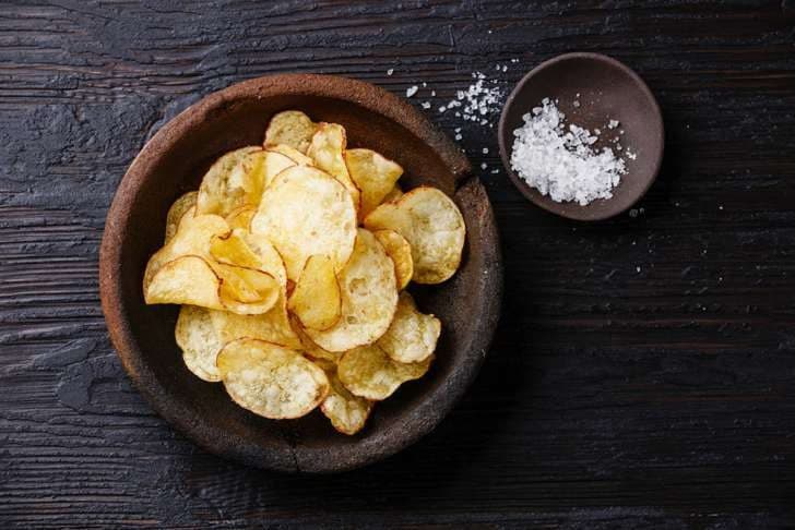 صورة Chips في صحن بالقرب من وعاء به ملح.