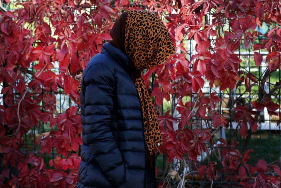 امرأة مسلمة متحجبة واقفة بجانب جدار