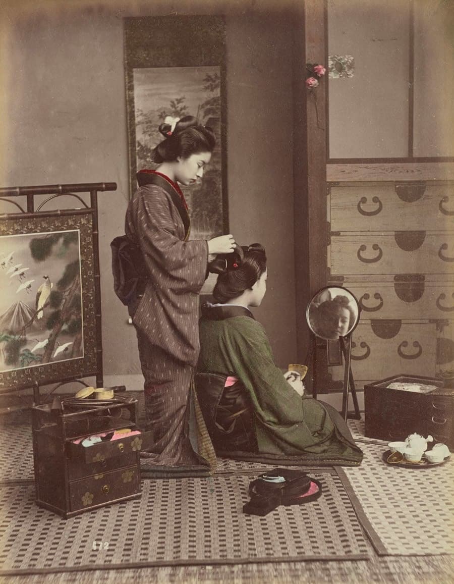 امرأة تساعد أخرى على تسريح شعرها بين عامي 1870 و1900