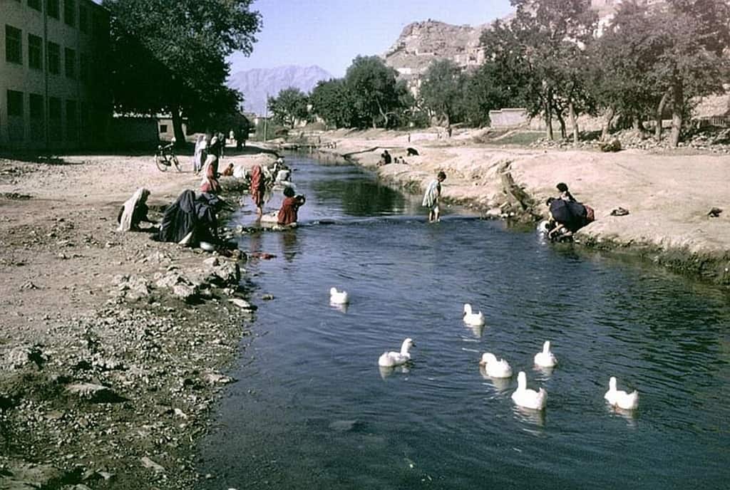 أطفال يلعبون بالماء ونساء يغسلن