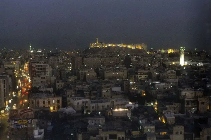 صورة لمدينة حلب عند المساء؛ تظهر في الصورة قلعتها الشهيرة ومنارة مسجدها الأمويّ.