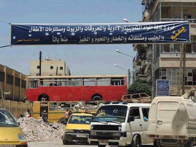 معبر الموت الحلبيّ؛ تشير اللافتة إلى منع توصيل المواد الغذائيّة إلى الطرف الآخر من حلب.