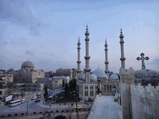 مسجد التوحيد يتوسط كنيستي الكلدان وكنيسة مار جرجس في حي العزيزيّة بوسط حلب.