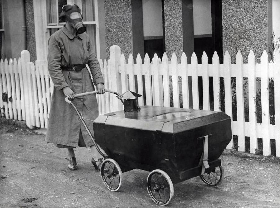 امرأة بريطانية ترتدي قناع غاز وتدفع عربة أطفال مقاومة للغازات السامة عام 1938