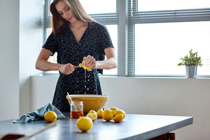 امرأة تقوم بتحضير عصير الليمون في وعاء