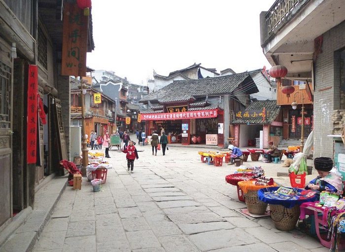 شارع مدينة صينية قديمة به مجموعة من السكان
