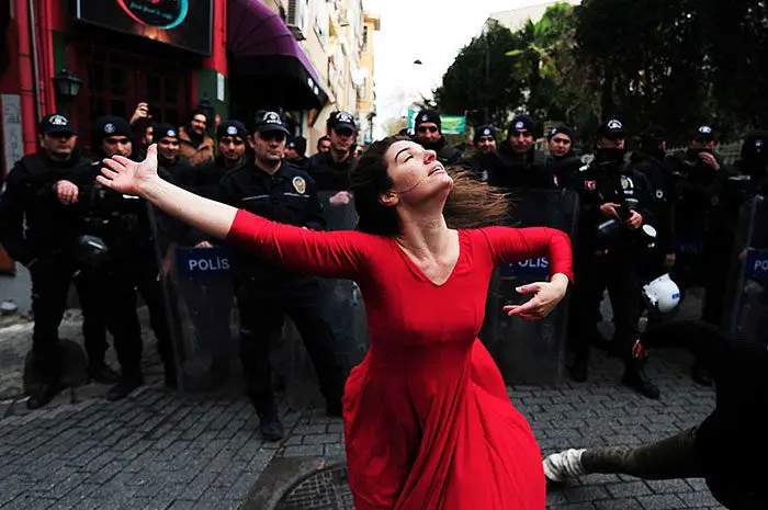 امرأة ترقص أمام شرطة مكافحة الشغب خلال تظاهرة ضد إخلاء مبنى عشوائي، وذلك في حي (كاديكوي) Kadikoy في اسطنبول، في 9 كانون الثاني/ديسمبر 2014.