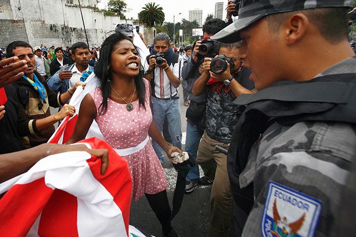 امرأة أفريقية - إكوادورية تتجادل مع الشركة التي تحرس سياجاً أمام الجمعية الوطنية في (كيتو) Quito خلال احتجاج على مشروع خصخصة المياه المُقتَرح، والذي سينعكس سلباً على السكان الأصليين، بتاريخ 5 أيار/مايو 2010.