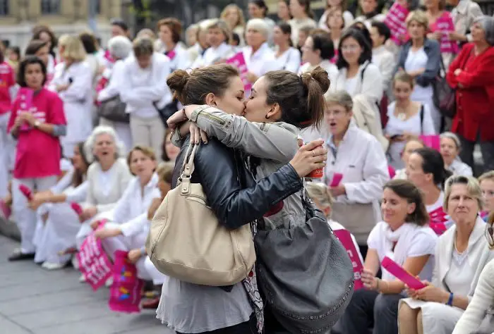 امرأتان تقبلان بعضهما خلال مظاهرة ضد زواج المثليين في فرنسا، سنة 2012