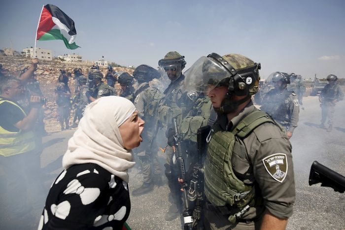 امرأة فلسطينية تتجادل مع شرطي حدود اسرائيلي خلال احتجاج ضد المستوطنات اليهودية في قرية (النبي صالح) في الضفة الغربية في فلسطين.