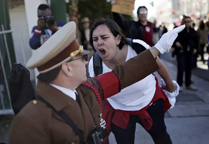 امرأة تصرخ في وجه رجل بزي (أدولف هتلر) خلال احتجاج في السبت الخاص بالزحف النسوي ضد تنصيب الرئيس الجديد (دونالد ترامب) في (لاس فيغاس – الولايات المتحدة الأمريكية) بتاريخ 21 كانون الثاني/يناير 2017.