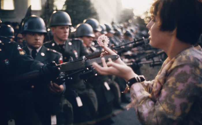 شابة من دعاة السلام تدعى (جين روز كاسمير) تضع زهرة على حِراب حراس البنتاغون خلال تظاهرة ضد حرب فيتنام، 21 تشرين الأول/أكتوبر 1967.