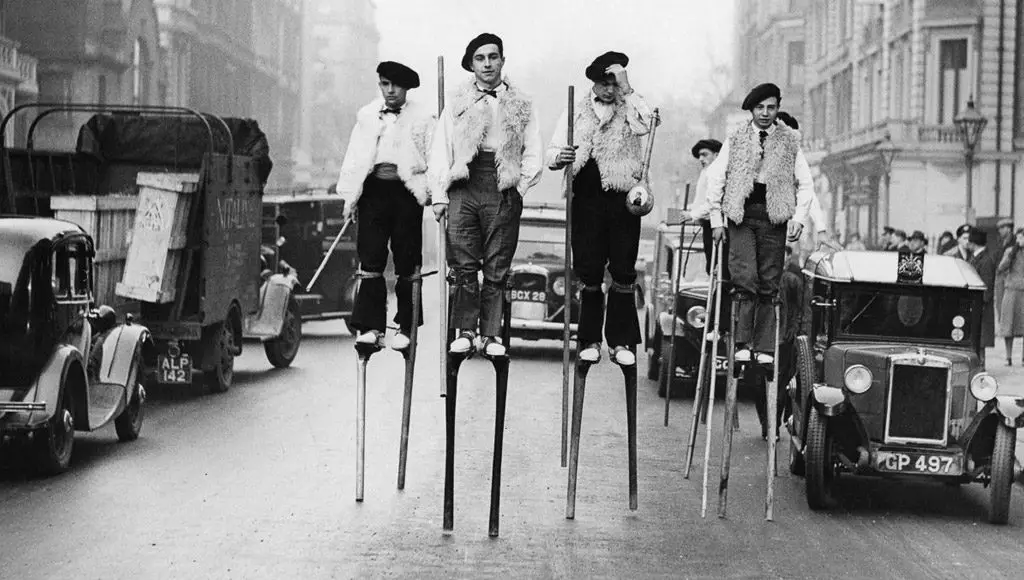 راقصون على السيقان الخشبية من منطقة (اللاند) يمشون في شوارع (لندن) في طريقهم إلى أدائهم عروض في (ألبرت هال)، في التاسع من شهر يناير سنة 1937.