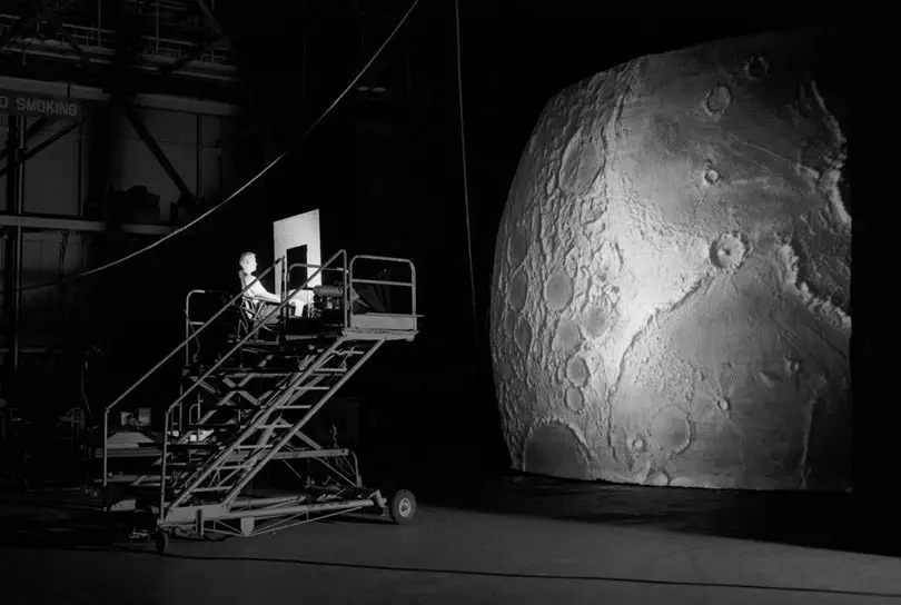 موظف اختبار على جسر رافعة متحرك يتفحص محاكاة لسطح القمر خلال بدايات إجراء الاختبارات على مشروع LOLA.