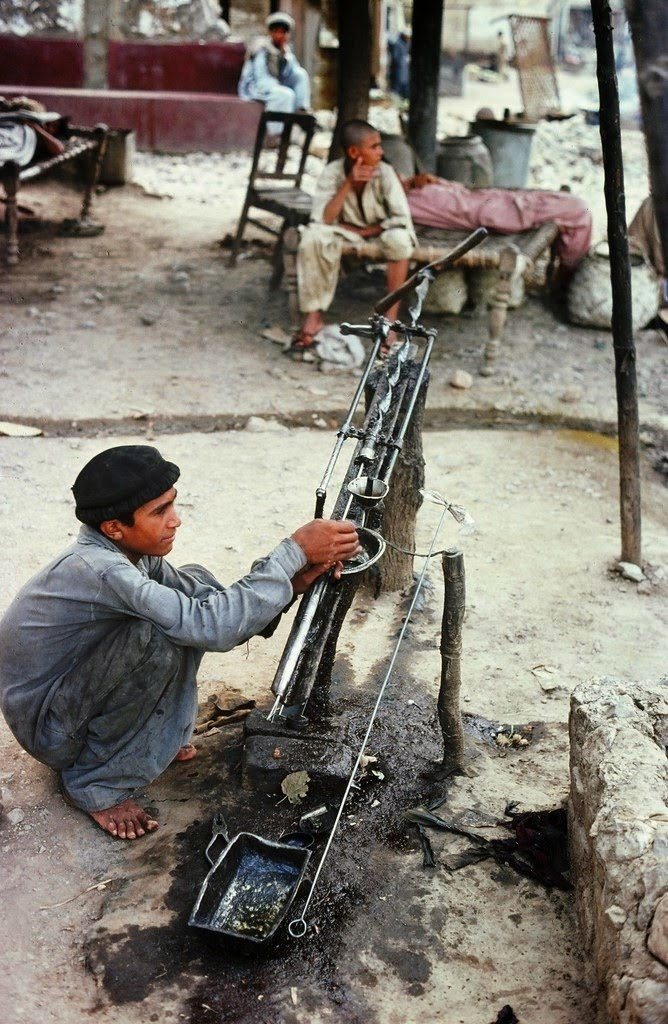 طفل يقوم بتصليح وصيانة إحدى الأدوات التقليدية التي تستخدم لصناعة الأسلحة في قرية (دره آدم خيل).