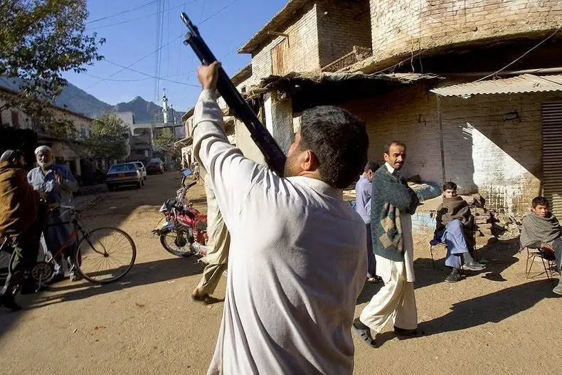 أحد تجار الأسلحة يجرب بندقية محلية الصنع