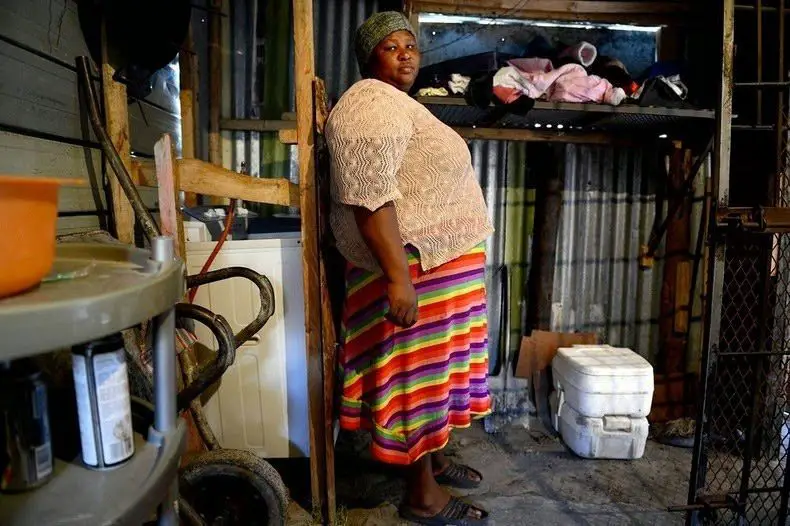 امرأة جنوب إفريقية أمام مرحاض منزلها