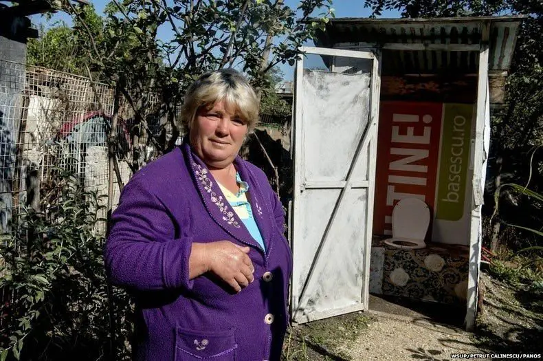 امرأة رومانية أمام مرحاض خارج منزلها