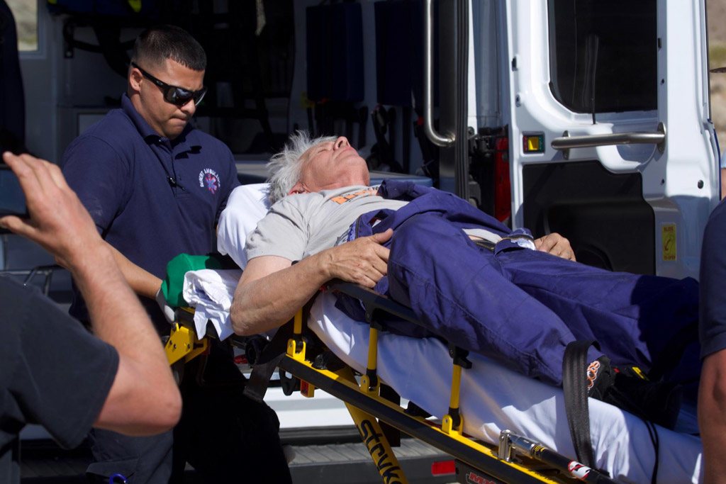 (مايك هيوز) بينما كان يتم نقله إلى داخل سيارة إسعاف فور هبوطه