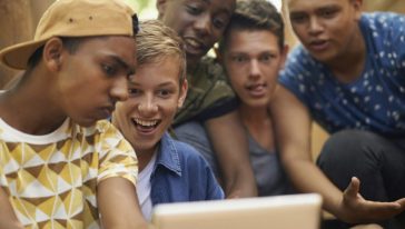 مجموعة من المراهقين يشاهدون أمرا ما على اللوح الإلكتروني