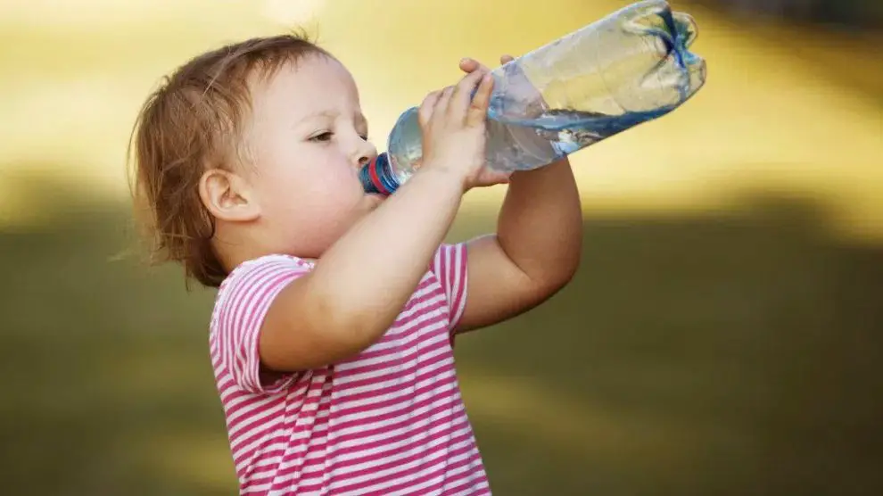 فتاة صغيرة تشرب المياه من الزجاجة مباشرة
