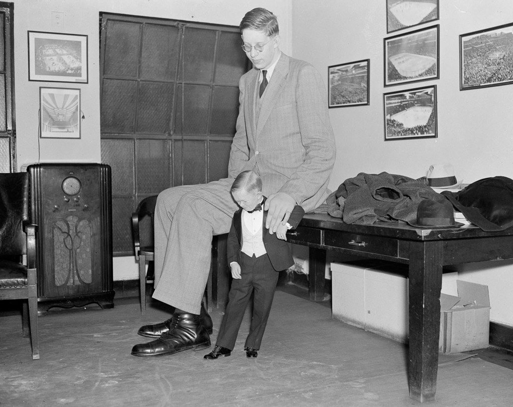 صورة لـ(روبرت وادلو) وهو يقارن مقاس حذائه مع (رينغلنغ بروس)، وهو رجل صغير الحجم يعمل معه في السيرك.