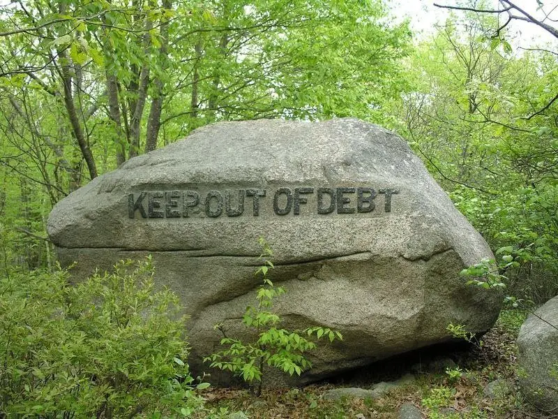 حجر تذكاري في مؤسسة أبحاث الجاذبية نقش عليه: "إبق بعيدا عن الديون"