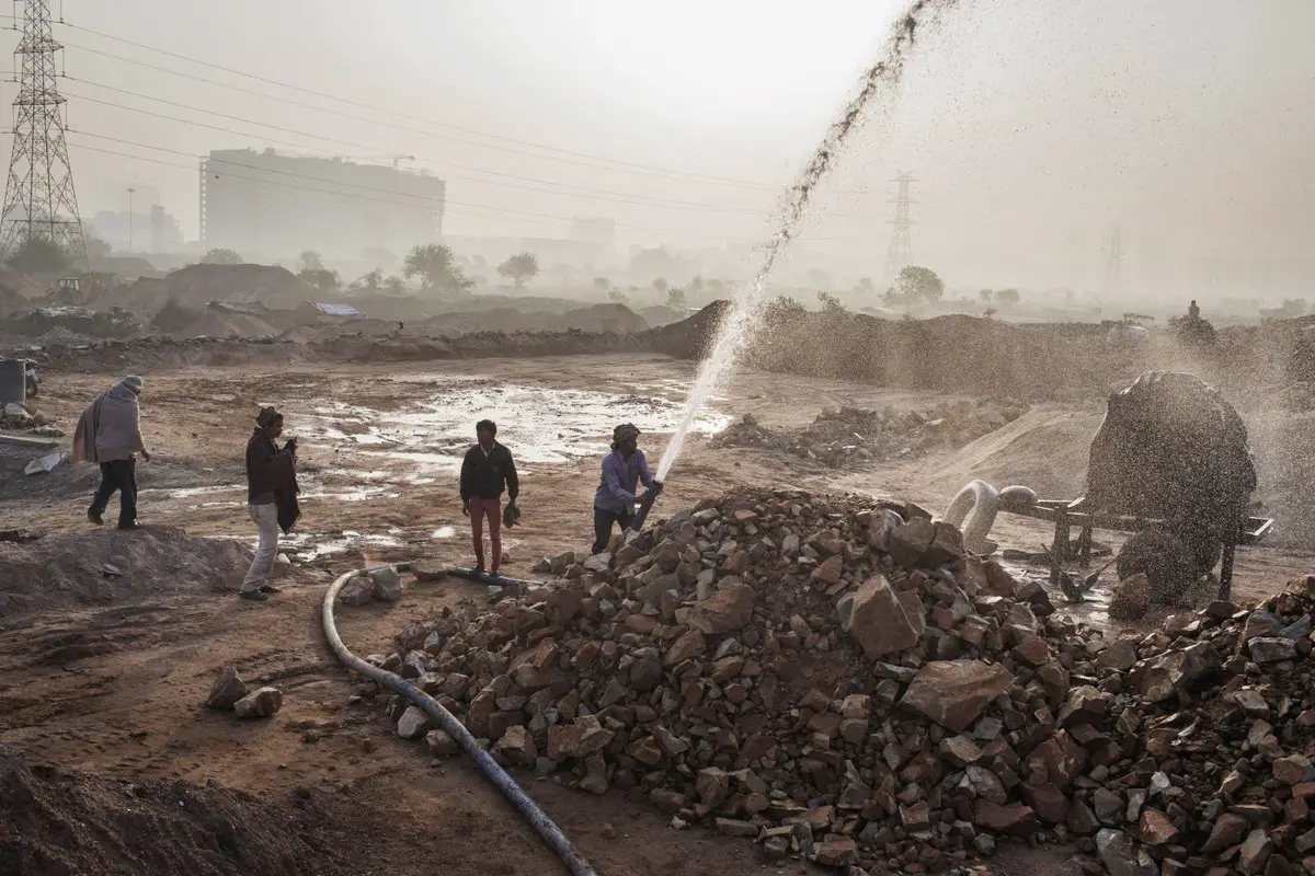  عمال وهم يغسلون الحجارة قبل أن يتم سحقها وتحويلها إلى رمال في منجم غير شرعي قرب قرية (ريبور).