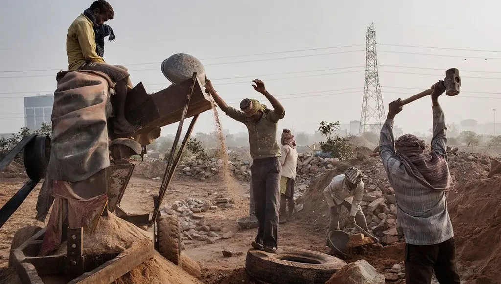  عمال هنديون يحطمون ويسحقون الحجارة لتحويلها إلى رمال في منجم غير قانوني قرب قرية ريبور Raipur في الهند وذلك في 18 مارس عام 2015.