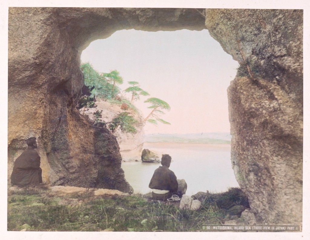 رجل يشاهد البحر من داخل تشكيل صخري جميل في (ماتسوشيما) حوالي سنة 1890