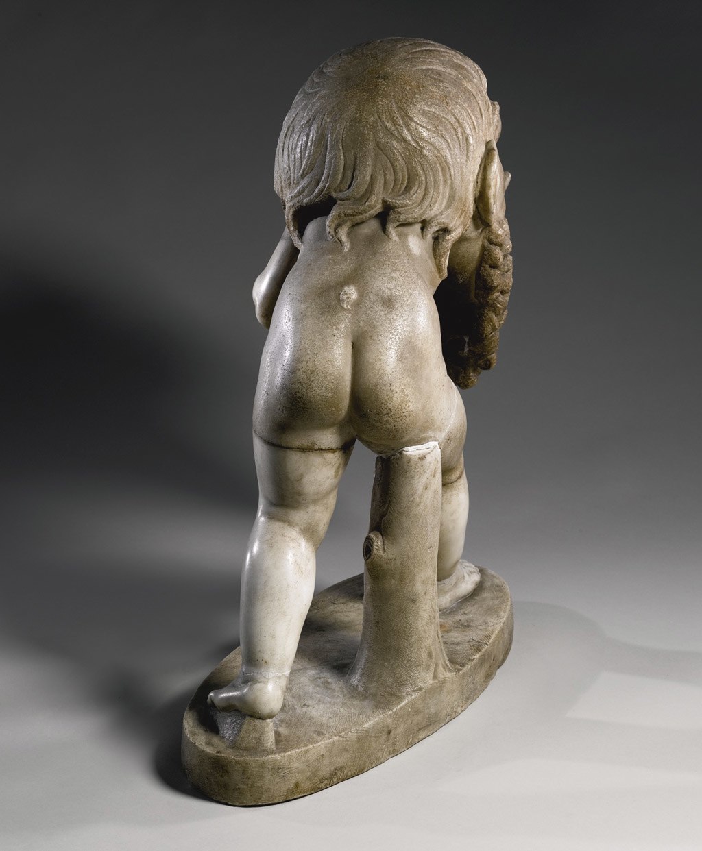 صورة خلفية لتمثال لأحد أتباع الاله (ديونيسوس) يرتدي قناع مسرح لـ(سيلينوس) يعود تاريخه إلى القرن الأول