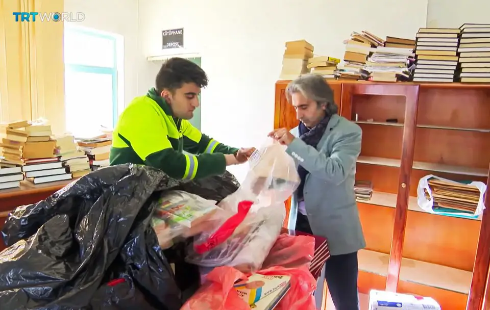 أمير علي أرتوكين مدير شركة (نورم) للتكنولوجيات برفقة أحد عمال النظافة يقوم بترتيب الكتب في المكتبة