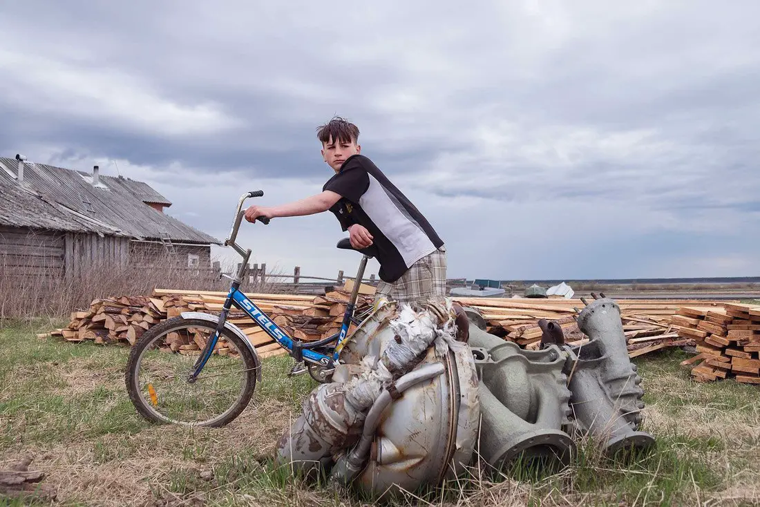يقف (أنطون) ذو الـ13 عاماً بالقرب من بقايا صاروخٍ في Dolgoshchelye.