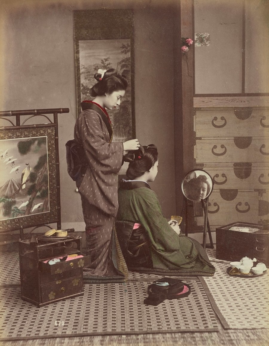 امرأة تساعد أخرى على تسريح شعرها بين عامي 1870 و1900