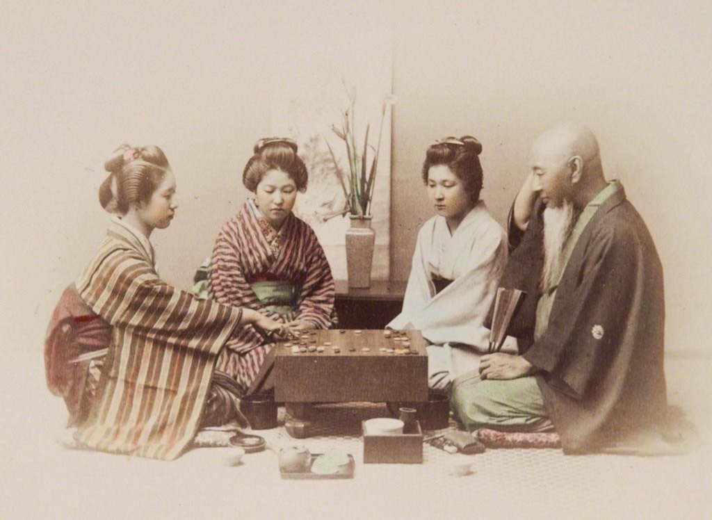 ثلاثة نساء ورجل كبير يمارسون لعبة (غو) الشهيرة في اليابان حوالي سنة 1890